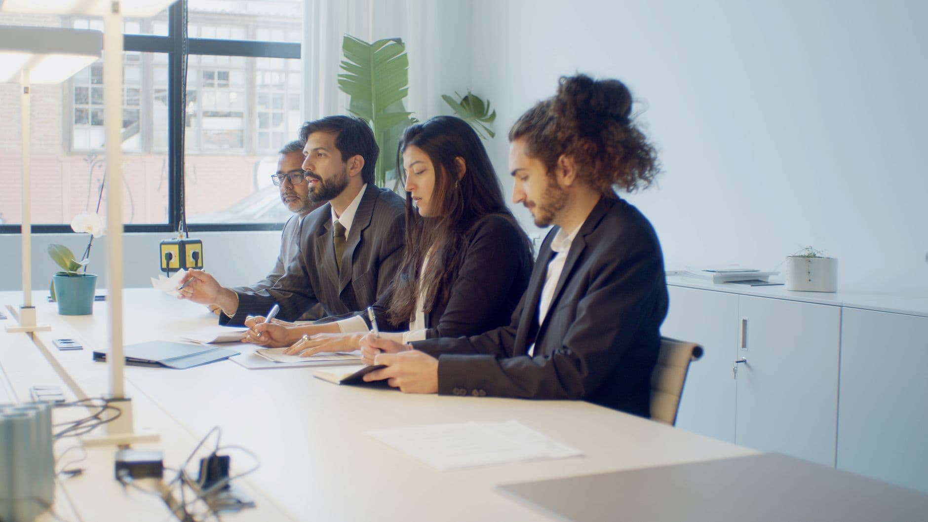 Accounting team members collaborating around a laptop in a modern office