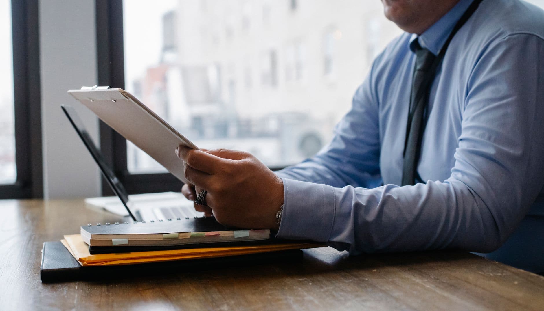 Agribusiness owner reviewing documents for multiple business entities at a desk