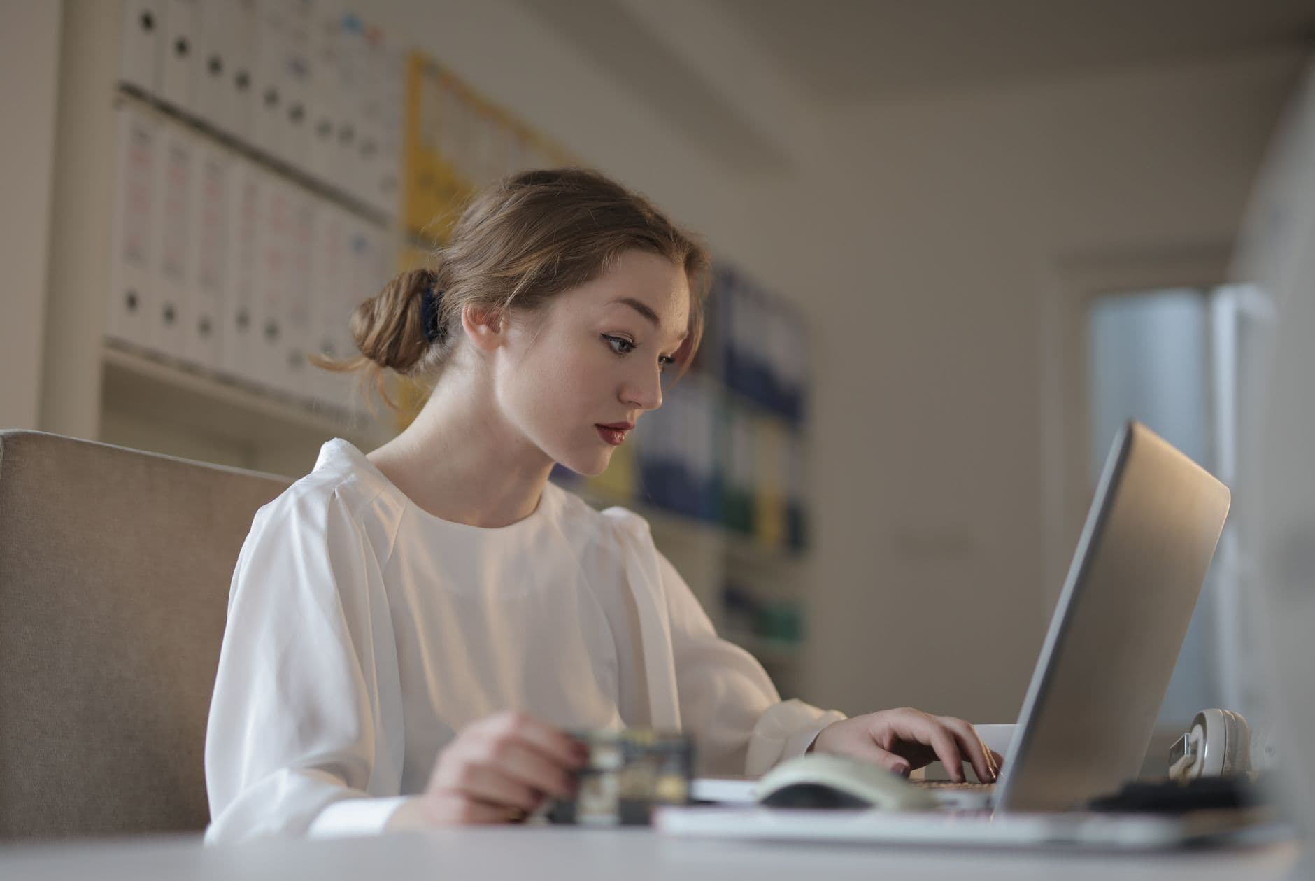 Bookkeeper classifying transactions and reconciling accounts on a laptop
