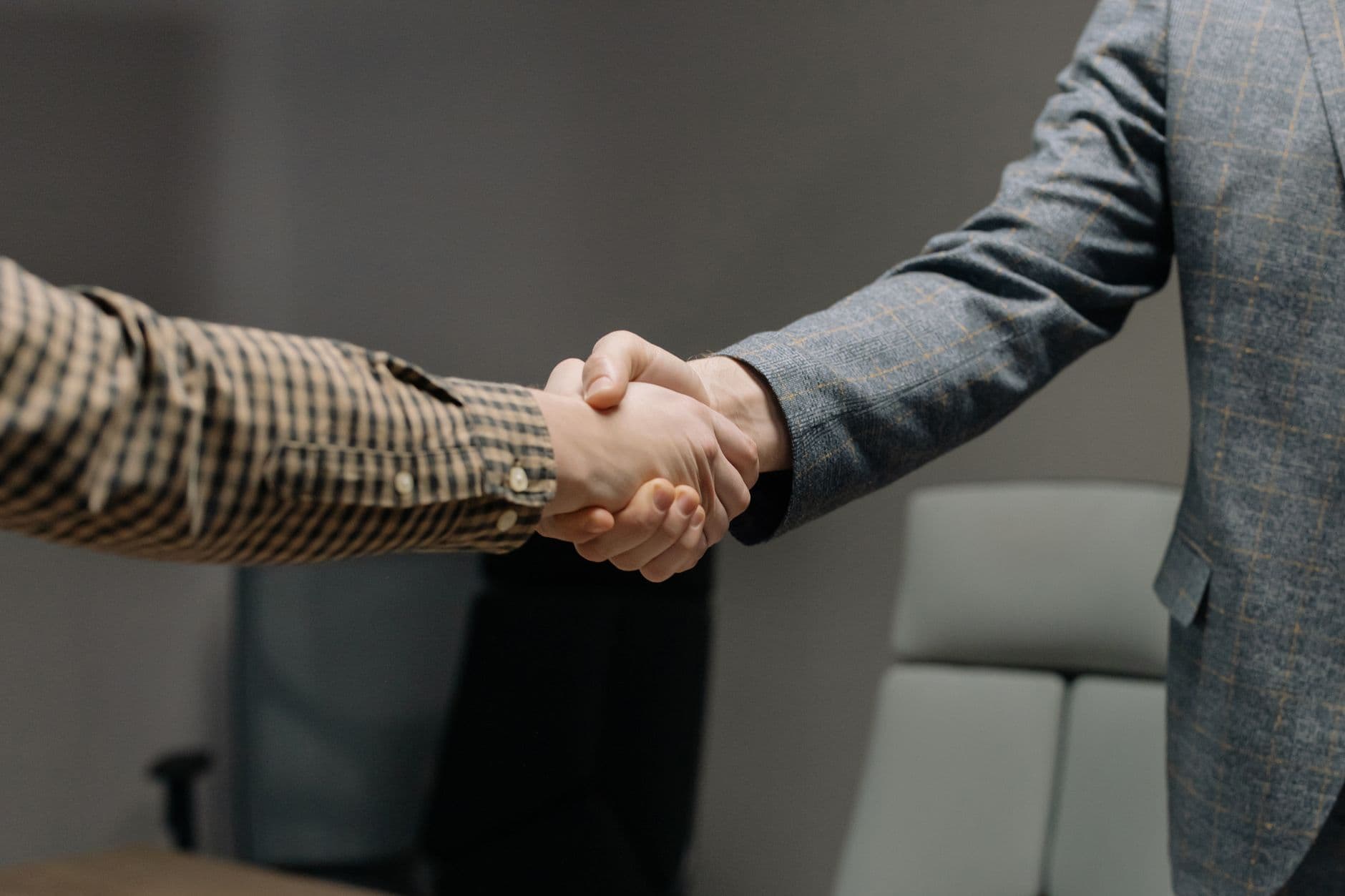 Accountant shaking hands with a farmer in a farm office setting