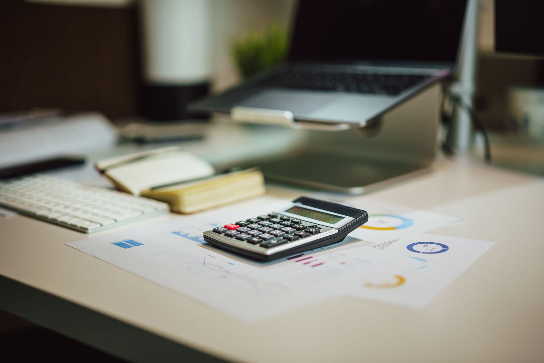 Desk with financial statements, calculator, and payroll documents organized for review