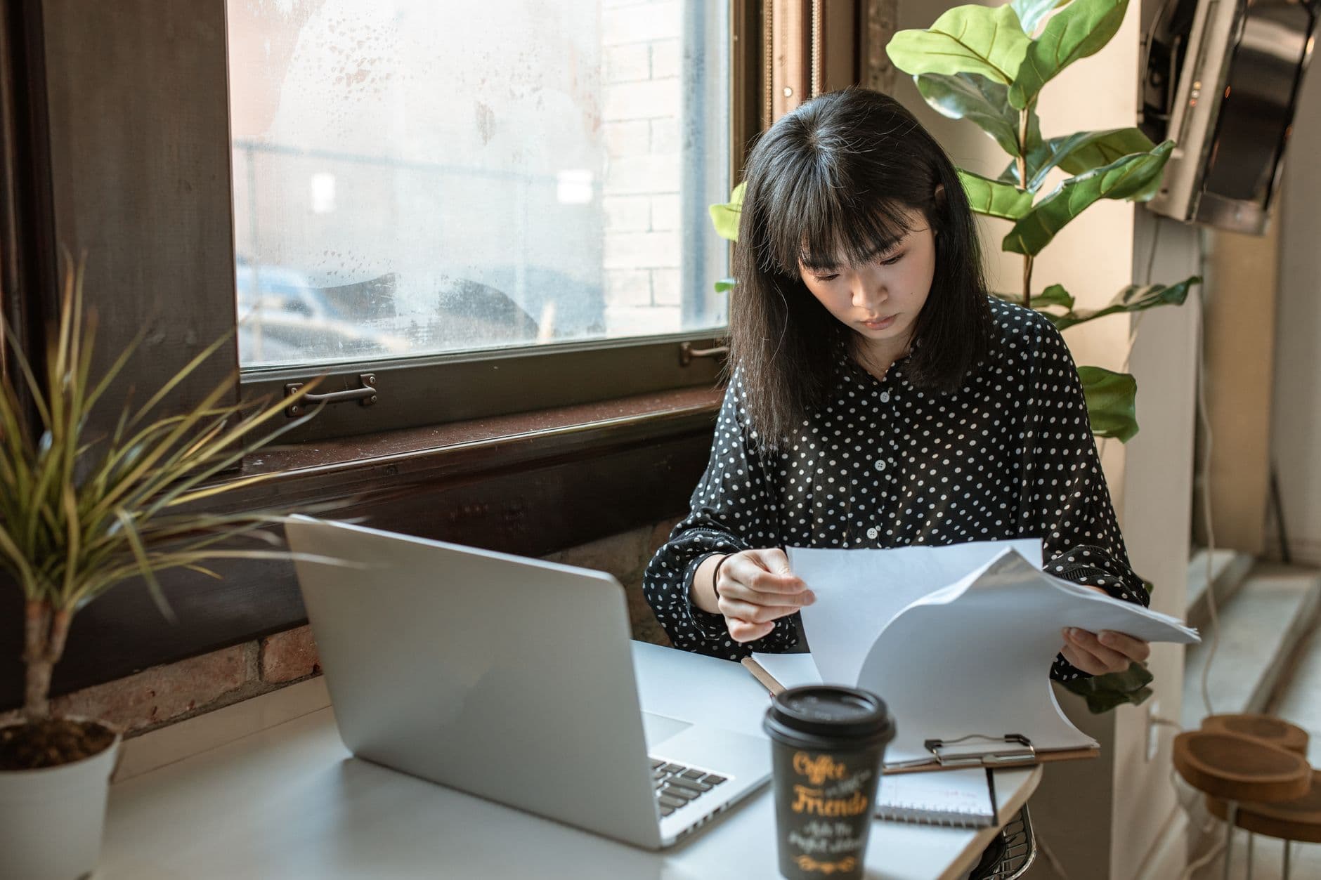 Business owner reviewing new client paperwork on a laptop