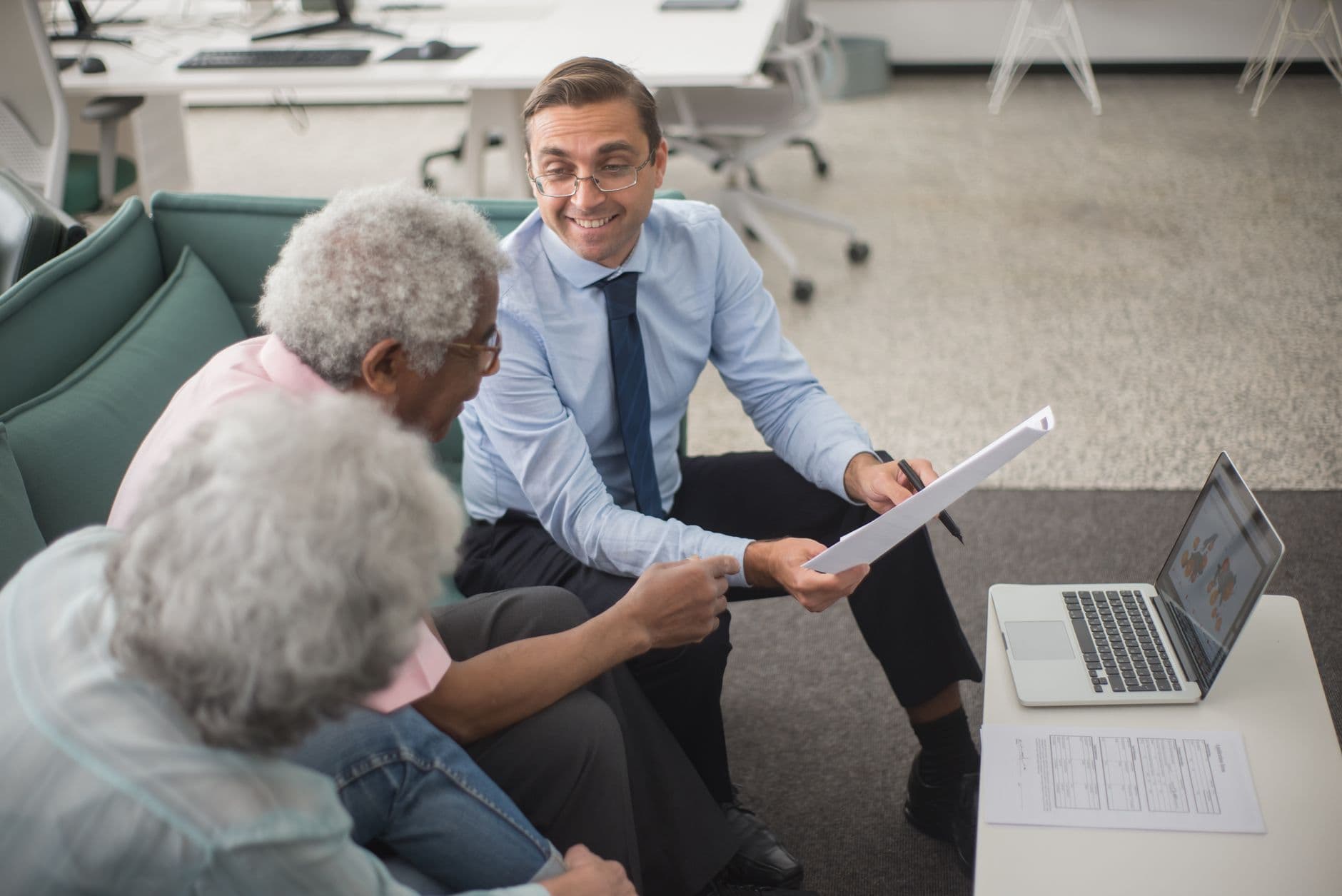 An older couple sitting at a kitchen table reviewing financial paperwork together for long-term care planning