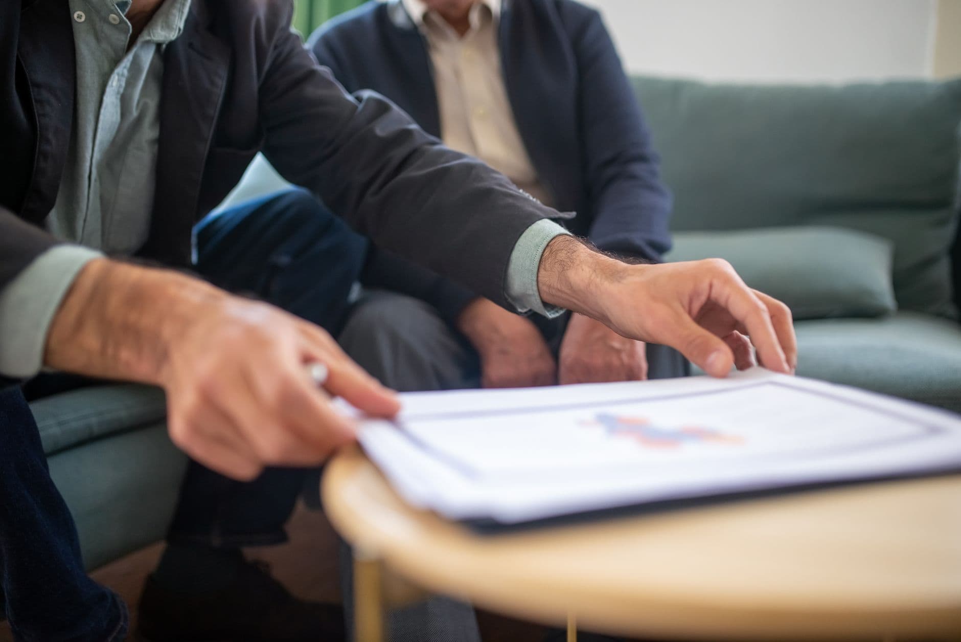 Farmer and accountant reviewing financial paperwork together outdoors