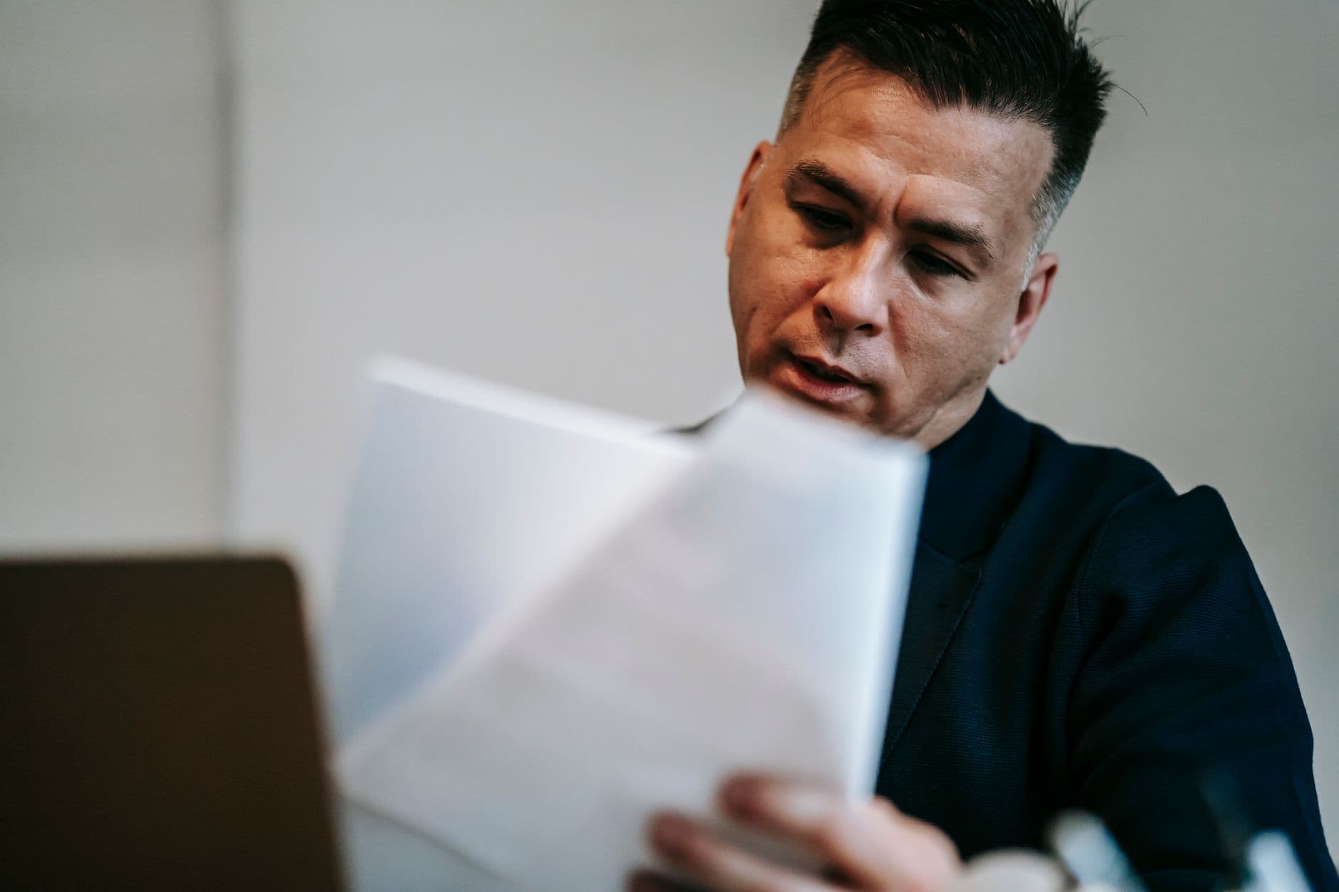 Farmer reviewing equipment purchase records alongside financial statements