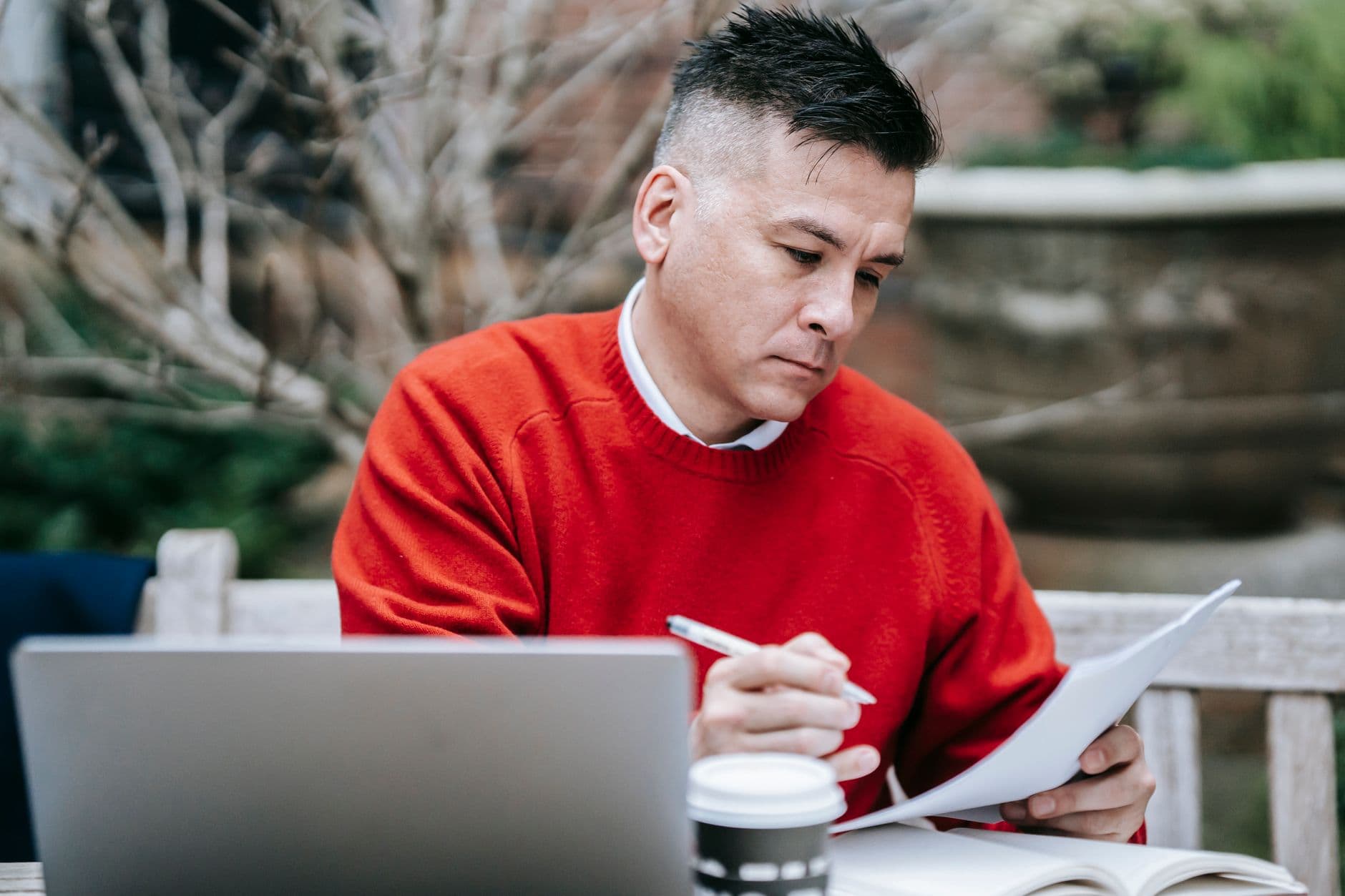 Farmer reviewing financial reports at a kitchen table with a laptop