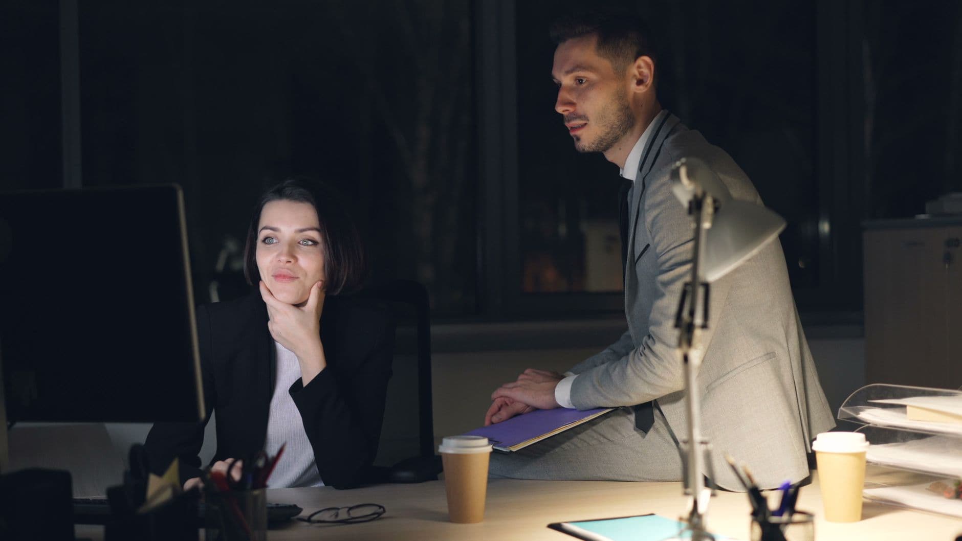 A tired farm business owner reviewing financial paperwork late at night at a kitchen table